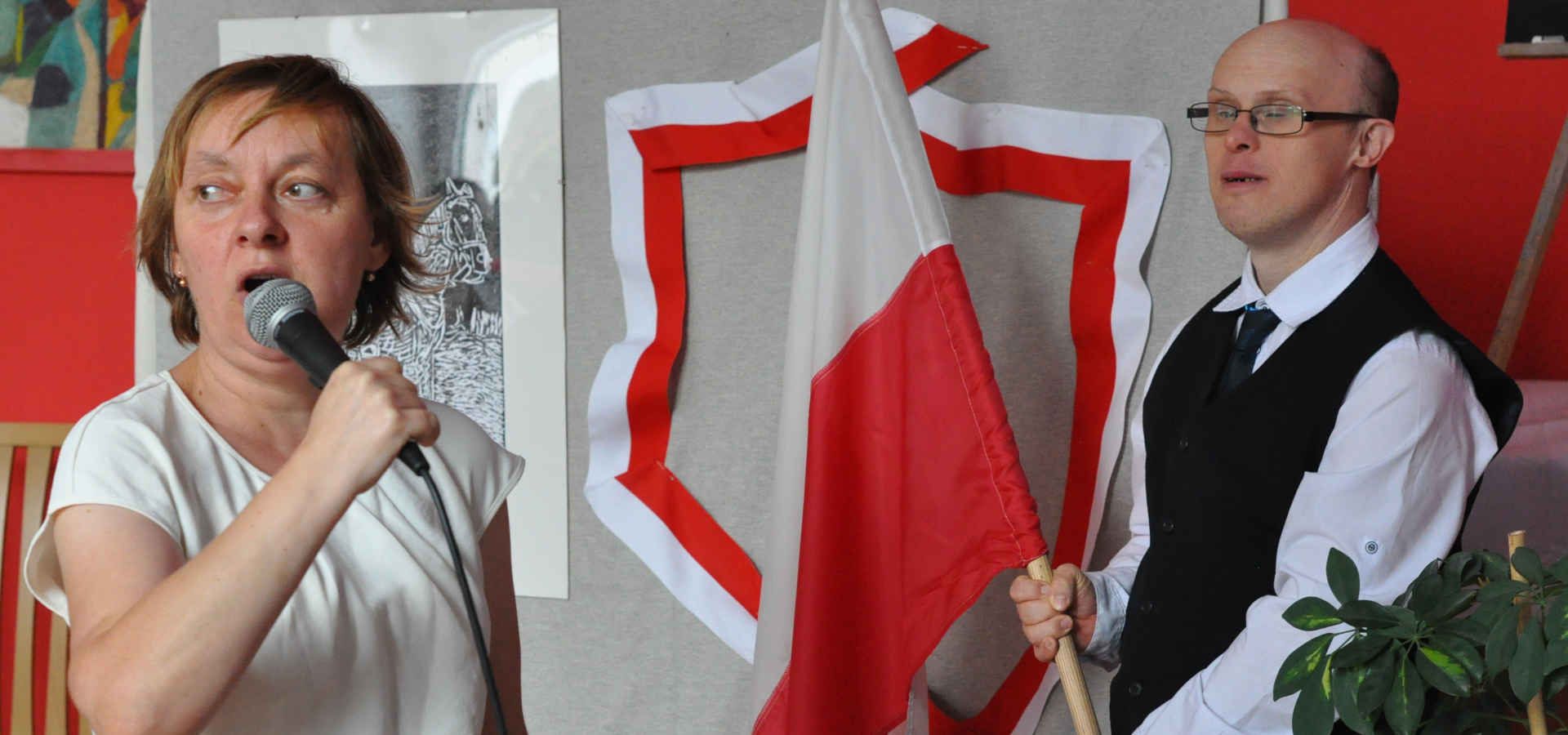 Mężczyzna trzyma flagę, kobieta śpiewa