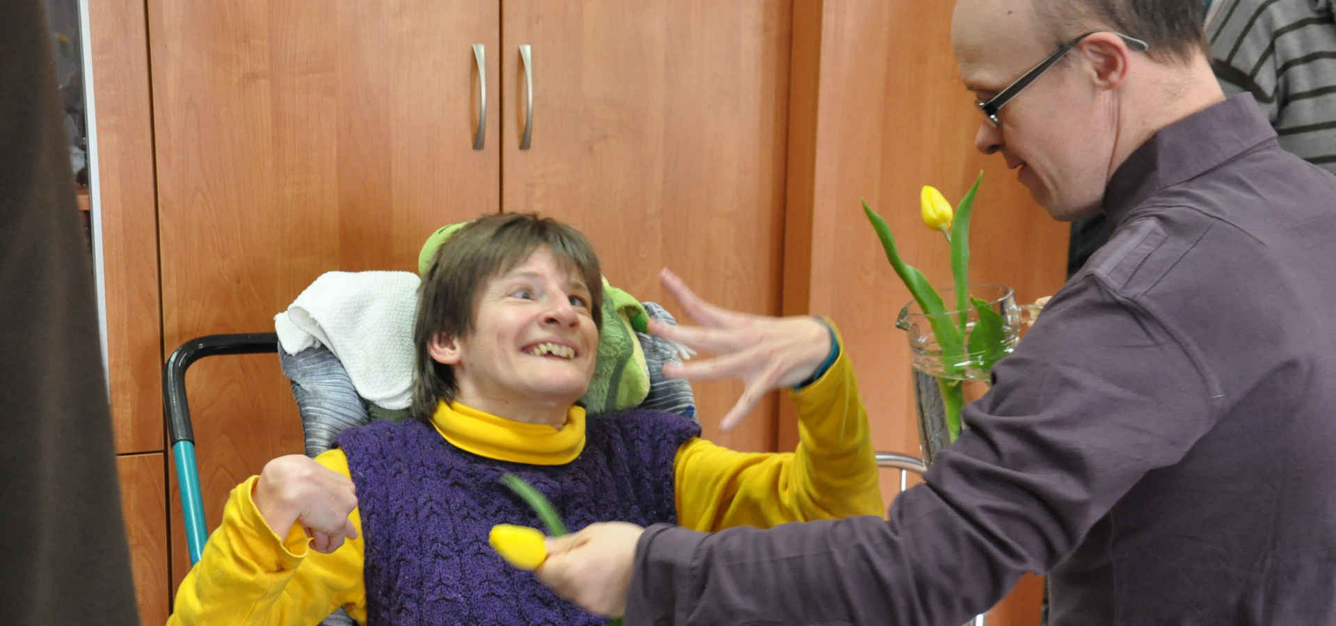 Mężczyzna daje tulipana kobiecie na wózku