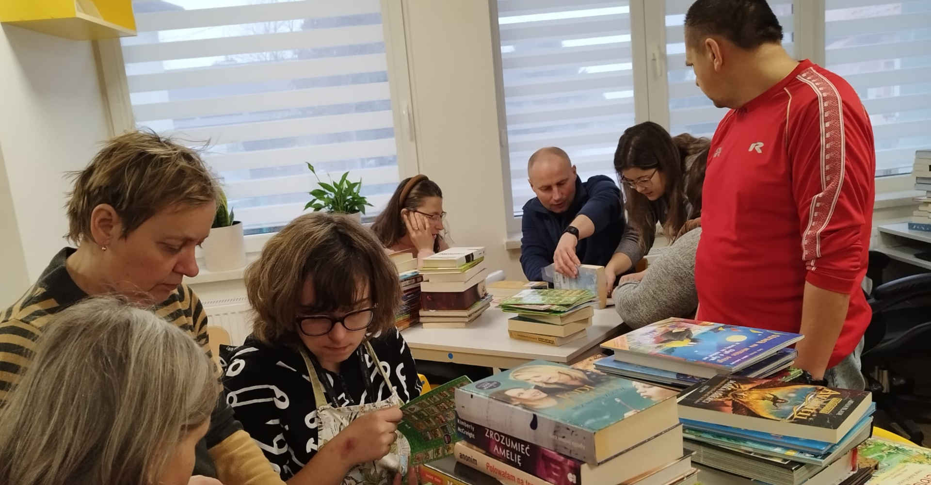 Uczestnicy domu samopomocy oddająca w bibliotece