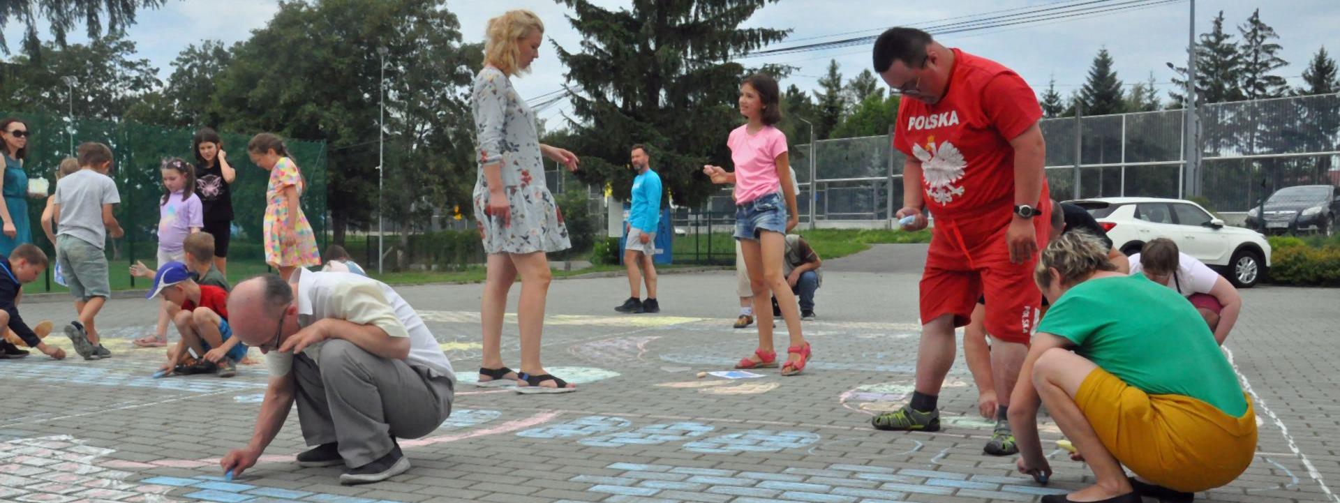 Uczestnicy spotkania malują kredą po kostce